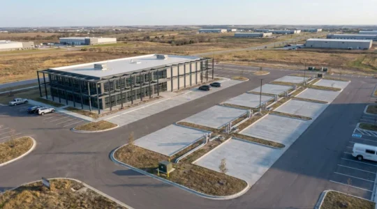 Vue aérienne d'un bâtiment industriel moderne avec structure métallique et zones d'extension planifiées